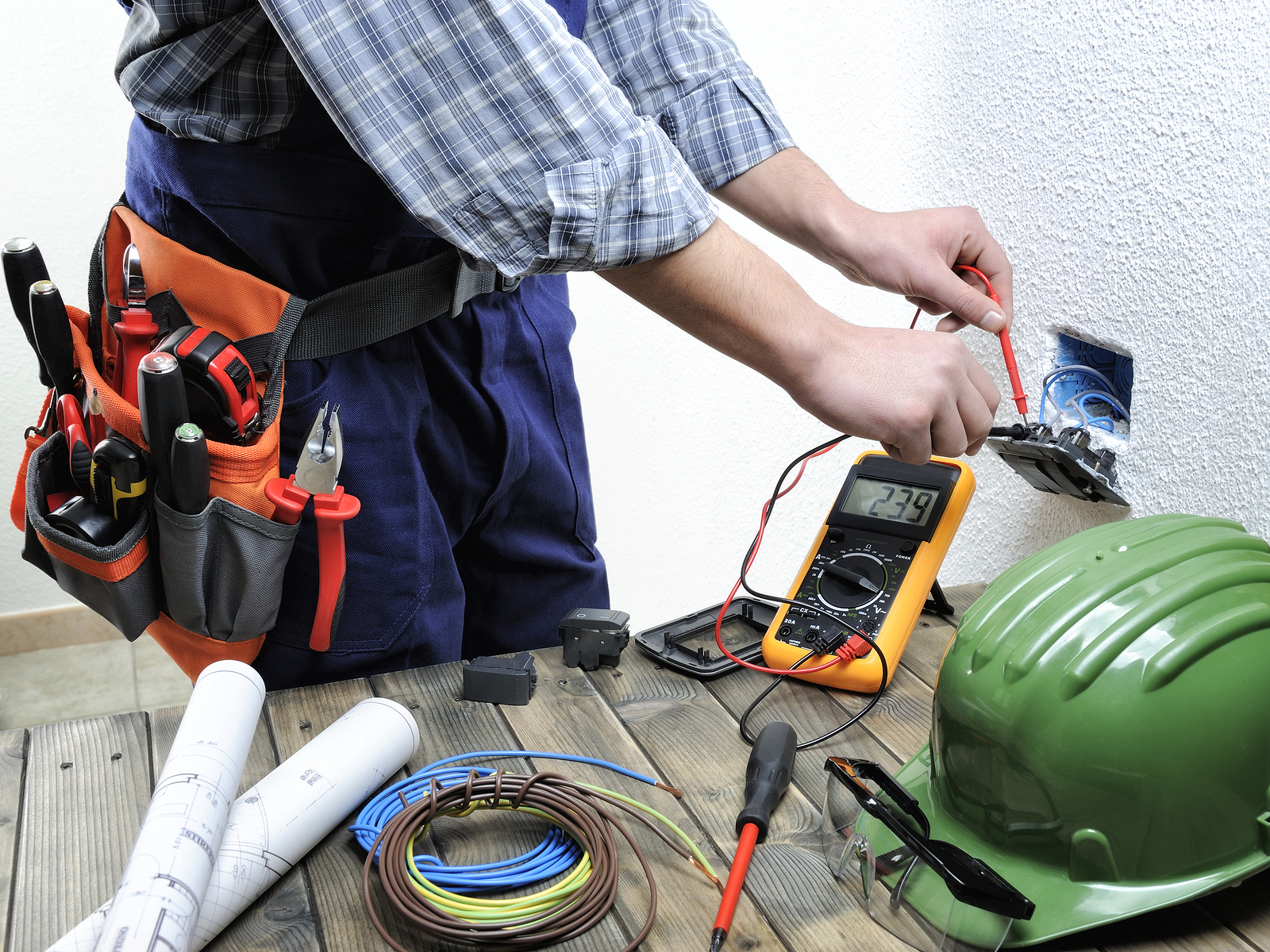 bigstock-220571488 Young electrician at work measures the voltage of a residential electrical installation.