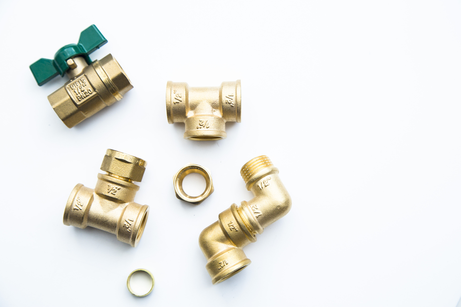 Various Plumbers Tools And Plumbing Materials Including Coper Pi Various plumbers tools and plumbing materials including coper pipe, elbow joint, wrench and spanner. Bright white background. Top view, copyspace