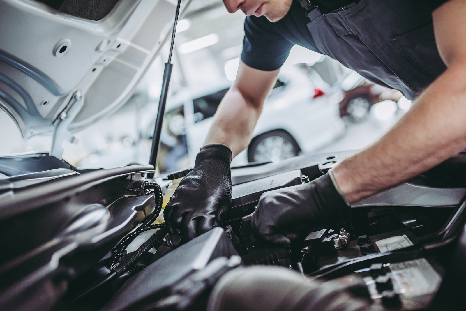 Handsome Auto Service Mechanic Cropped image of handsome mechanic in uniform is working in auto service. Car repair and maintenance.